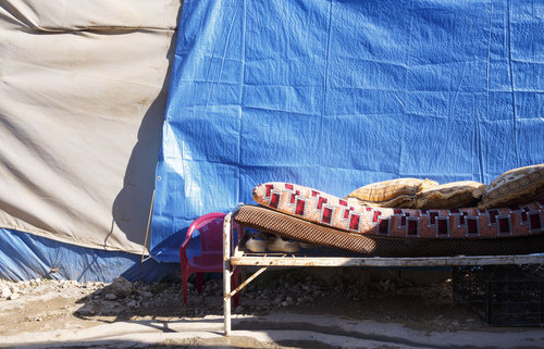 Bett mit Matratze und Schuhen im Freien im Fluechtlingscamp
