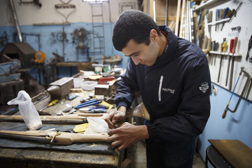 Junger Mann bei Intarsienarbeiten an einem Gewehr im Zentrum fuer Kunsthandwerk in Meknes