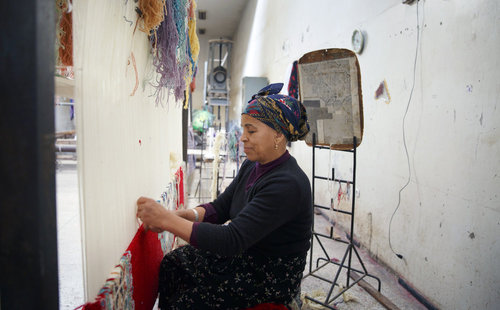 Frau beim Teppich knuepfen im Zentrum fuer Kunsthandwerk in Meknes