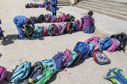 Schulranzen von Schuelern einer Doppelschichtschule in Amman