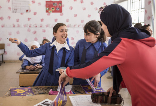 Lehrerin und syrische Schuelerinnen waehrend es Unterrichts an einer Doppelschichtschule in Amman