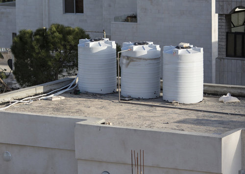 Wassertanks auf einem Hausdach in Amman