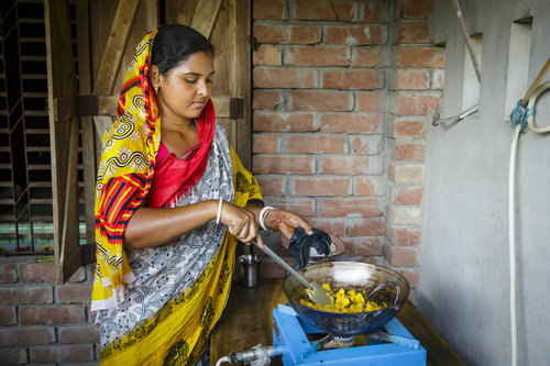 Junge Frau bei der Essenszubereitung in Bangladesch