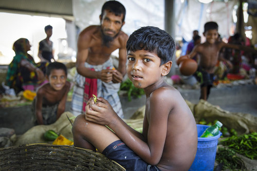 Essendes Kind auf einem Markt in Bangladesch