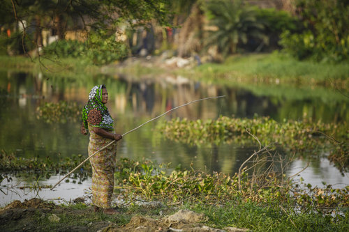 Frau beim Angeln in Bangladesch