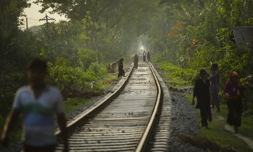 Fussgaenger auf einer Bahnstrecke in Bangladesch