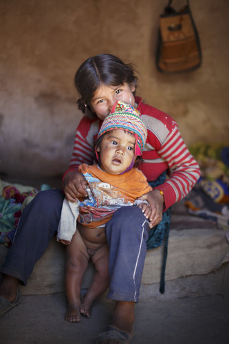 Kinder in einer Lehmhuette in den Anden von Bolivien