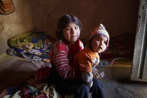 Kinder in einer Lehmhuette in den Anden von Bolivien