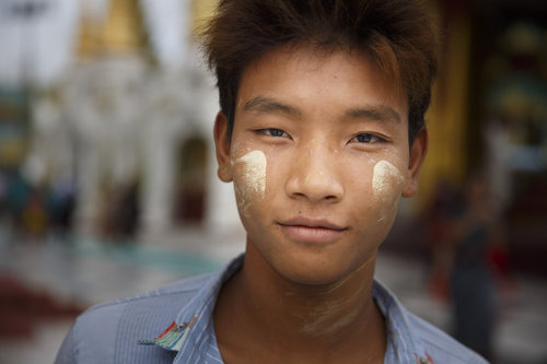 Junger Mann in Rangun traegt Thanaka im Gesicht
