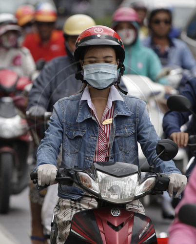 Rollerfahrer mit Schutzmaske in Ho Chi Minh Stadt