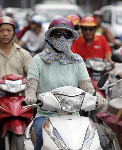 Rollerfahrer mit Schutzmaske in Ho Chi Minh Stadt