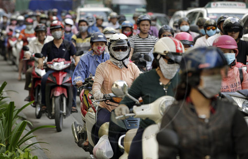 Rollerfahrer mit Schutzmaske in Ho Chi Minh Stadt