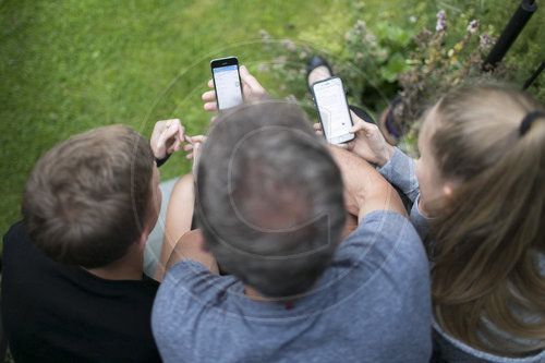 Vater und Kinder mit Smartphones