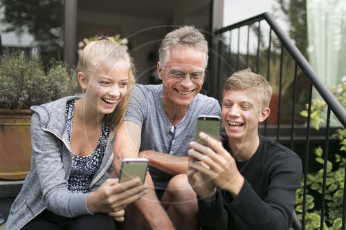 Vater und Kinder mit Smartphones