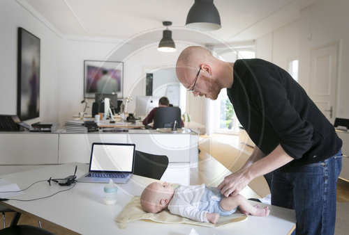 Vater und Baby am Arbeitsplatz
