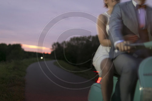 Mann und Frau auf einem Motorroller auf dem Weg zum Standesamt