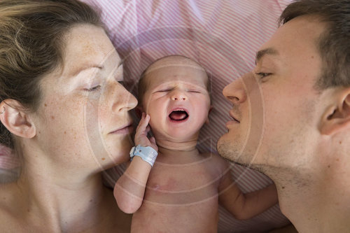 Neugeborenes Baby zwischen seinen Eltern