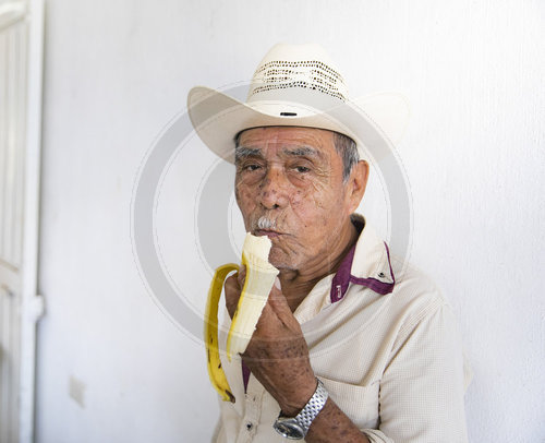 Bananenbauer isst Banane