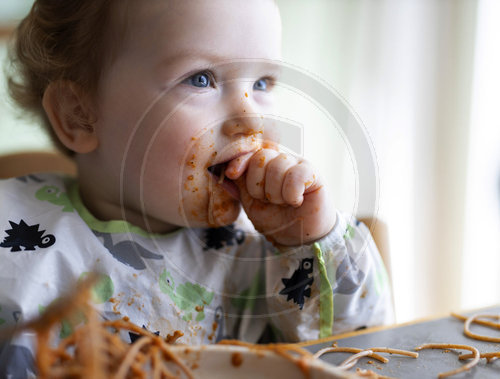 Kleinkind isst Nudeln mit Tomatensauce