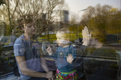 Eltern mit Kind hinter einem Fenster
