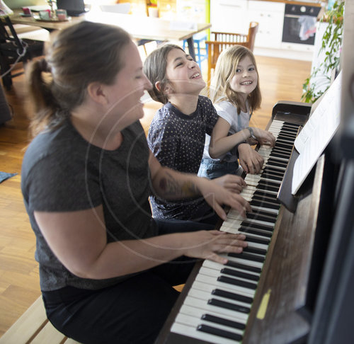 Mutter mit Kindern am Klavier
