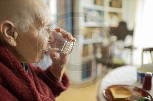 Alte Frau trinkt Wasser