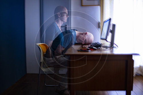 Mann sitzt zu Hause am Schreibtisch.