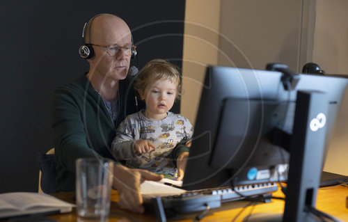 Mann mit Kleinkind am Schreibtisch