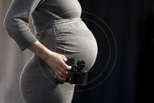 Schwangere Frau mit Fernglas