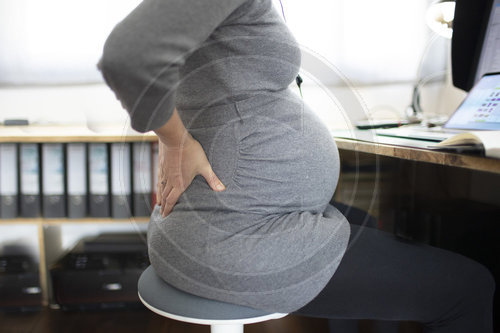 Junge schwangere Frau mit Rueckenschmerzen