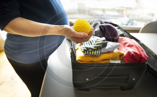 Schwangere packt Koffer fuer Klinik