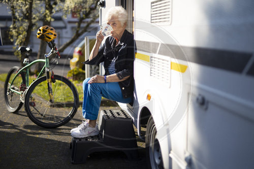 Thema: Rentnerin vor ihrem Wohnwagen.