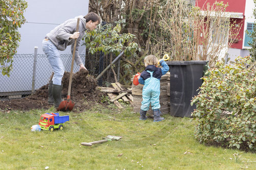 Vater und Kind spielt im Garten