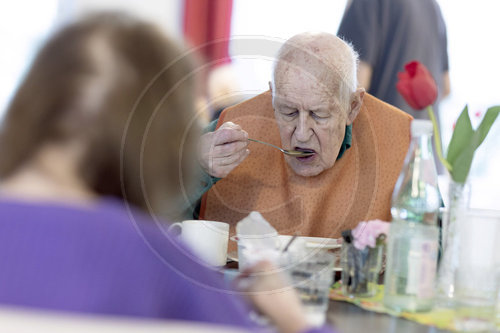 Alter Mann im Pflegeheim loeffelt eine Suppe