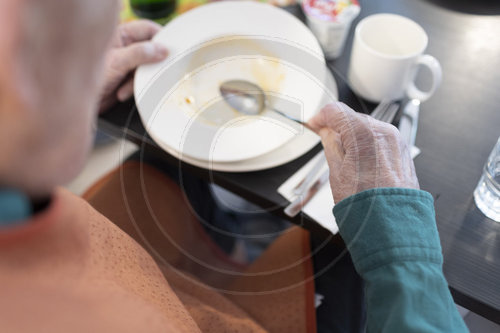 Alter Mann im Pflegeheim loeffelt eine Suppe