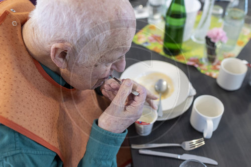Alter Mann im Pflegeheim loeffelt einen Nachtisch