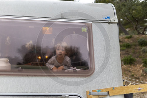 Kind bei Regenwetter in einem Wohnwagen