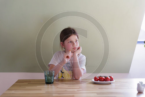 Kind sitzt am Esstisch