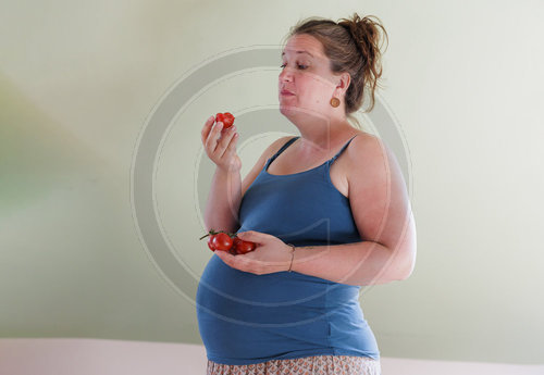Schwangere Frau isst Tomaten