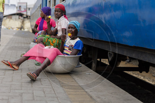 Maedchen sitzen am Bahnhof und warten