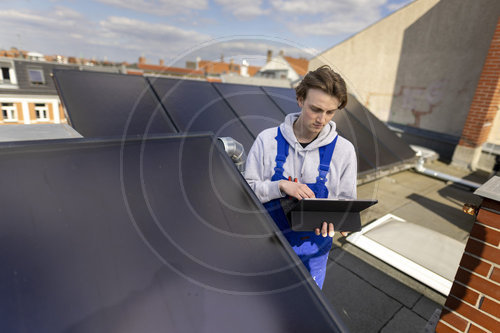 Ein Mann kontrolliert Solarkollektoren