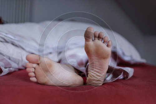 Dirty feet in a bed