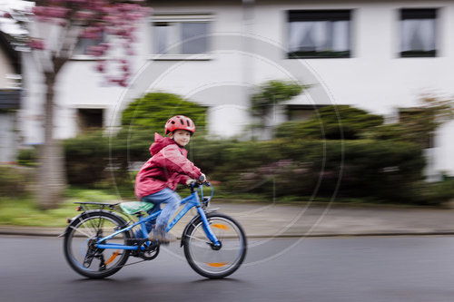 Kind mit Fahrrad/Laufrad auf der Strasse