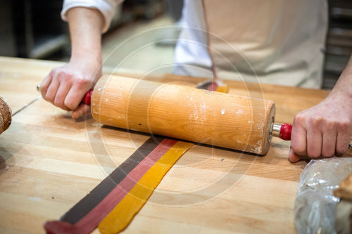 Baecker rollt Teig aus