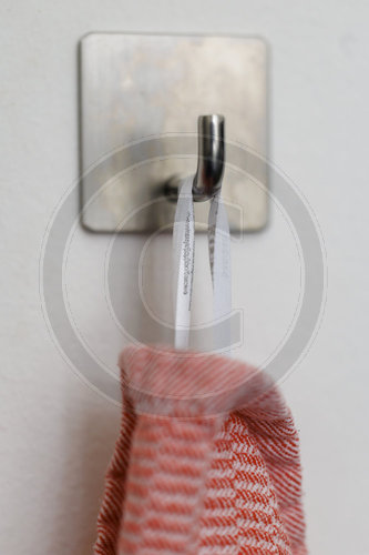 Geschirrtuch haengt an einem Haken.
